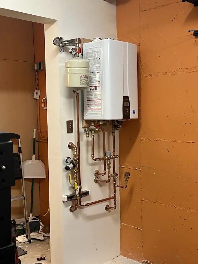 Plumbing technician inspecting water heater connections in Estelle